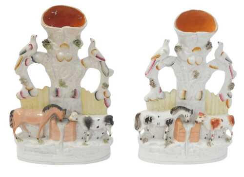 A pair of Victorian Staffordshire flatback spill vase figure groups, with birds on a bough over...
