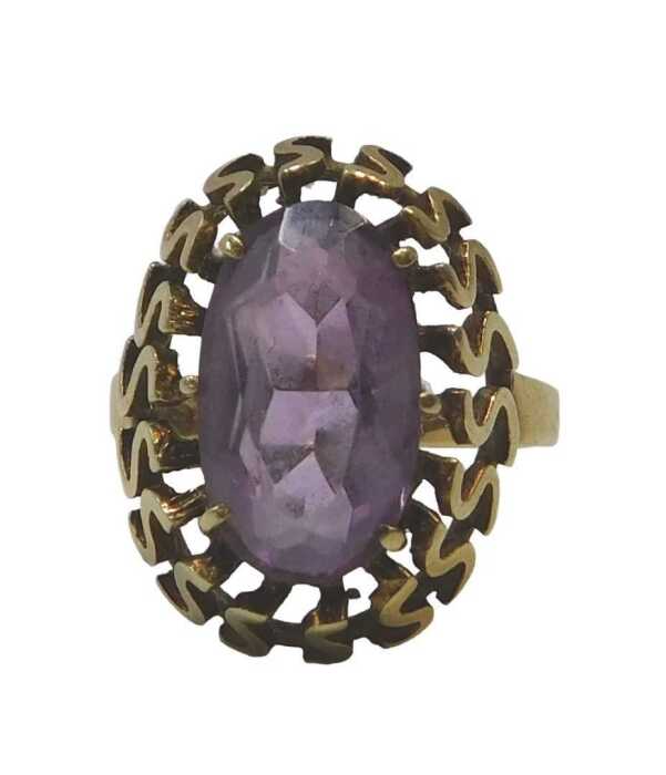An amethyst dress ring, the oval cut amethyst in a six claw raised basket setting, with S design...