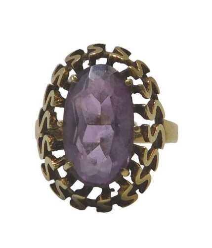 An amethyst dress ring, the oval cut amethyst in a six claw raised basket setting, with S design...
