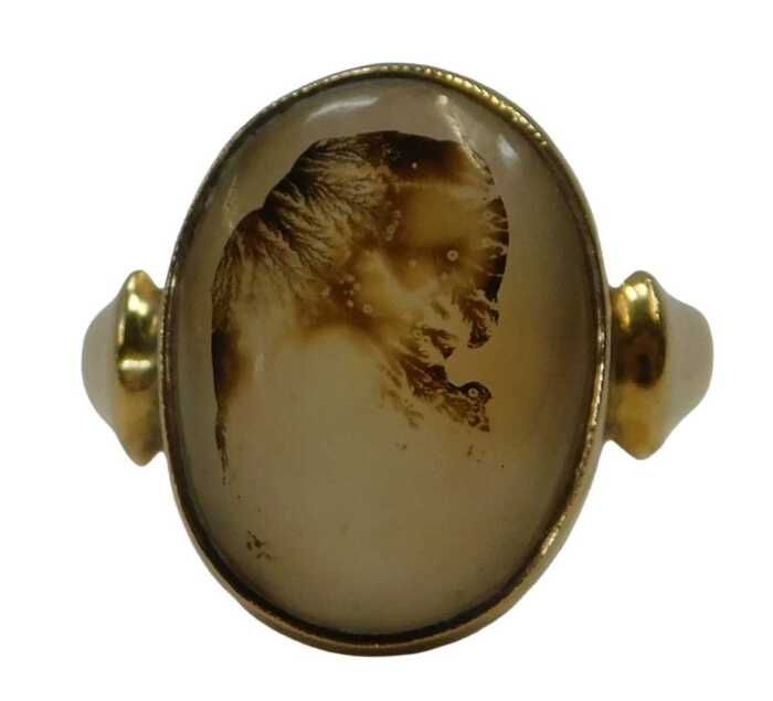 An 18ct gold moss agate dress ring, the oval-cut moss agate with visible natural inclusions, in...