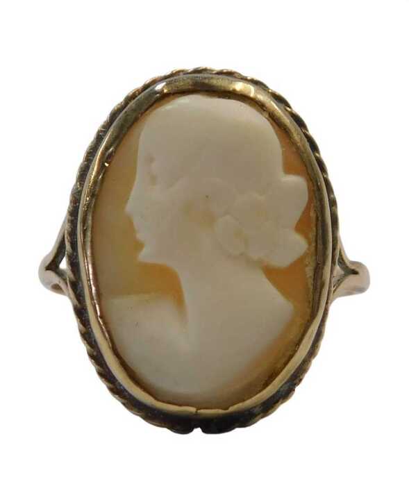 A shell cameo dress ring, quarter profile female facing sinister, in a rub over and pleated...