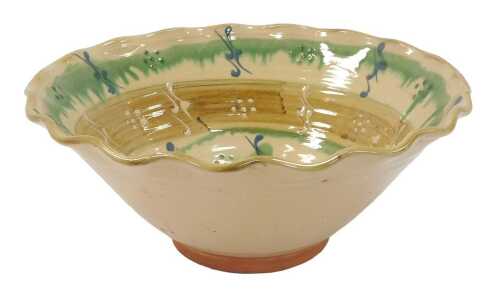 A 20thC studio terracotta bowl, with a waved border, decorated internally with banded dark...