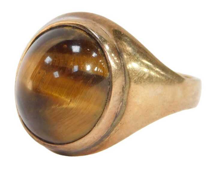 A 9ct gold tiger's eye dress ring, the polished cabochon stone in plain yellow metal mount, ring...