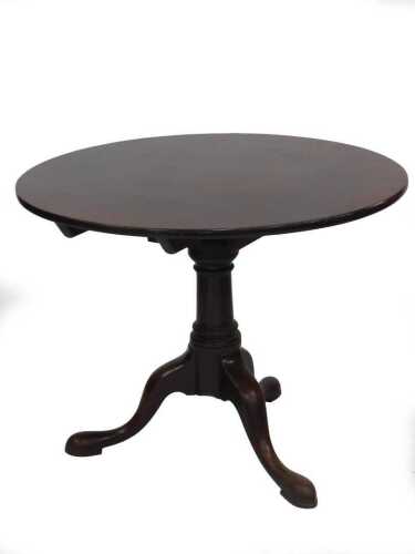 A George II mahogany supper table, with single piece circular tilt top, swivelling on a bird...