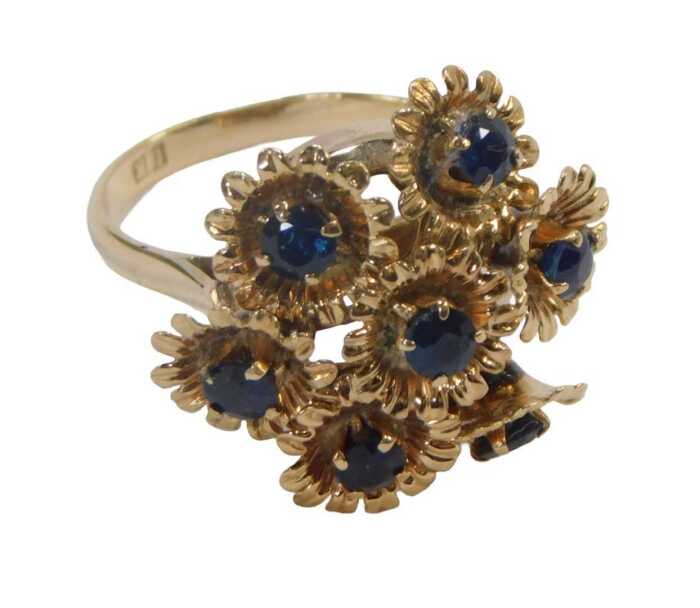 A 20thC floral cluster ring, formed as seven floral sections, on a frame, each with a round...