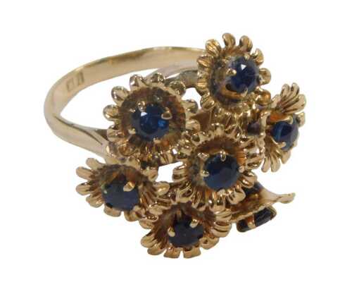 A 20thC floral cluster ring, formed as seven floral sections, on a frame, each with a round...