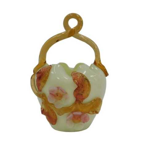 A uranium glass basket, with a twisted amber glass handle, the tapering body decorated with...