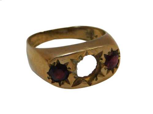 A 9ct gold and garnet three stone gypsy ring, central stone lacking, size O, 4.1g all in.