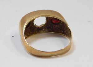 A 9ct gold and garnet three stone gypsy ring, central stone lacking, size O, 4.1g all in. - 2