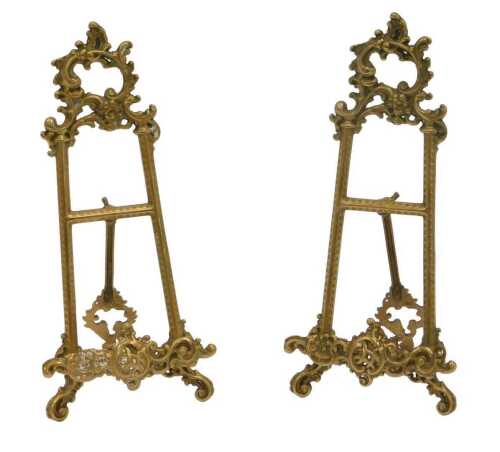 A pair of brass rococo-style tabletop easel picture stands, each decorated with scrolling motifs,...