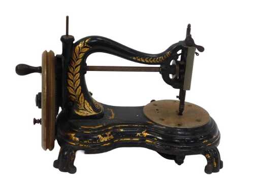 An early 20thC hand operated sewing machine, with partial gilt decoration, 34cm wide.
