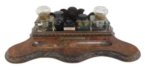 A Victorian carved oak desk stand, the raised back above a floral carved section with a lappet...