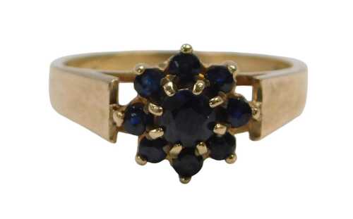 A 9ct gold cluster ring, set with nine dark blue sapphires, in a floral cluster setting,...