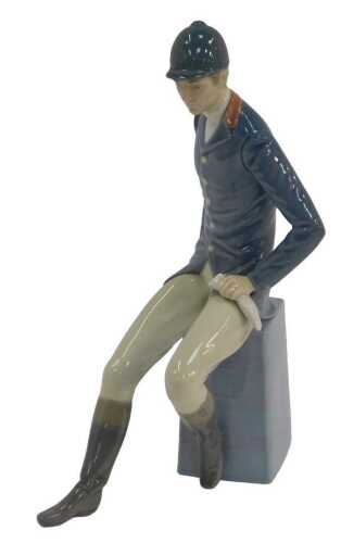 A Lladro porcelain figure, modelled as a gentleman in hunting clothing seated on a plinth, 28cm...
