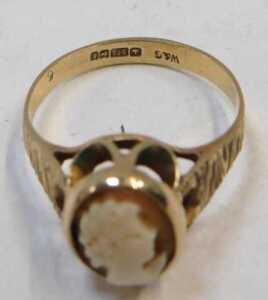 A 9ct gold shell cameo dress ring, the oval shell cameo in a rub over and petaled mount, on... - 2