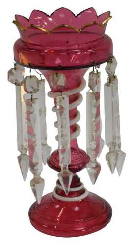 A Victorian cranberry glass lustre, with a gilt heightened rim, faceted glass drops, and milk...