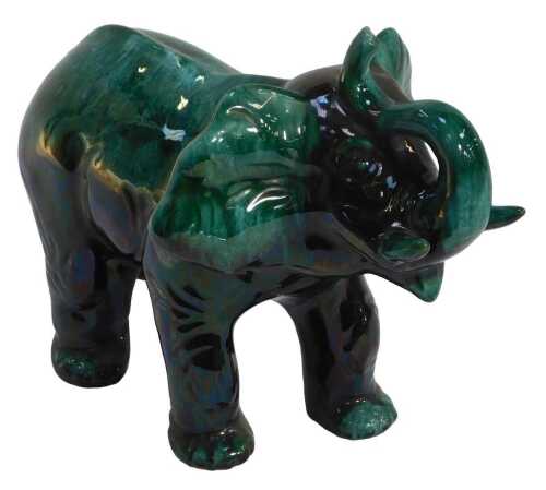 A Blue Mountain green glaze pottery elephant, modelled with trunk raised, 28cm high.