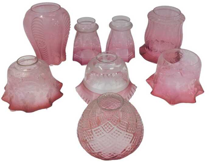 A group of Victorian and later cranberry glass oil lamp and other shades, predominantly etched...