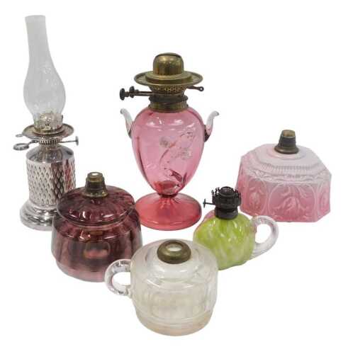 A group of Victorian and later oil lamp bases, central reservoirs, etc., to include a cranberry...