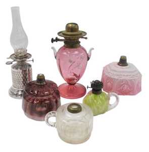 A group of Victorian and later oil lamp bases, central reservoirs, etc., to include a cranberry...