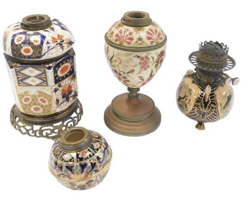 A group of oil lamp bases, to include a Zsolnay style pottery base, decorated with flowers, in...