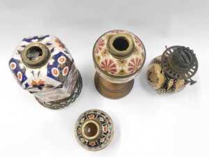 A group of oil lamp bases, to include a Zsolnay style pottery base, decorated with flowers, in... - 2