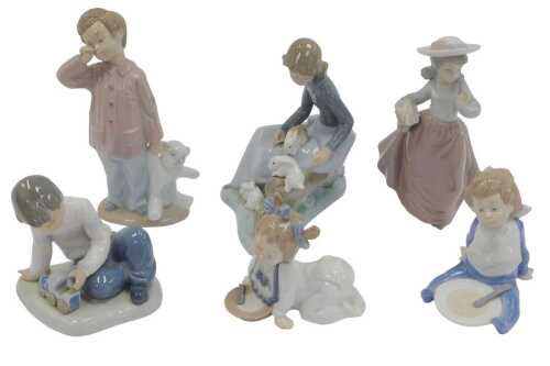 A group of Nao porcelain figures, to include a girl seated on a fallen tree trunk beside rabbits,...