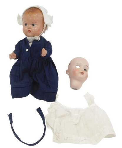 A mid 20thC composition doll, wearing a bonnet and blue dress with a pinny, 22cm high, together...