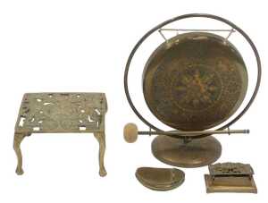 A group of brassware, comprising a gong, 26cm high, with striker, a pierced trivet, decorated...
