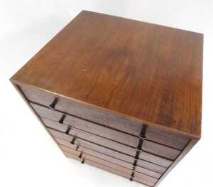 A 1970s teak tabletop chest, with a sloping top above five drawers, with a further faux drawer... - 2