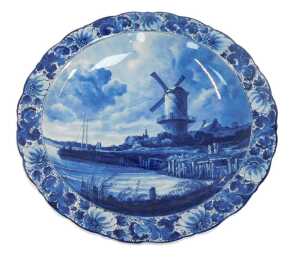 A 20thC Delft pottery charger, decorated centrally with a windmill before a river, within a...