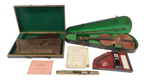 A group of musical instruments, comprising an autoharp, a zither, a penny flute, and a violin...