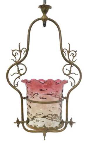 A Victorian cranberry glass hanging centre light, in a brass scrolling surround, 87cm high.