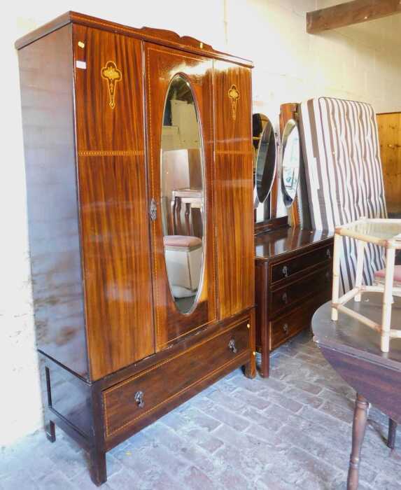A late 19thC/early 20thC Art Nouveau walnut wardrobe, the single door with bevelled oval mirror...