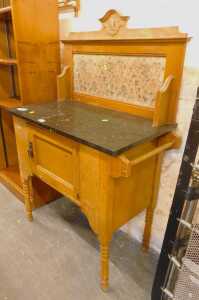 A late Victorian walnut washstand, the raised back with carved decoration and an inset floral...