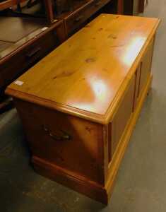 A pine blanket chest, with a panelled front and hinged top with a moulded edge, with two metal...