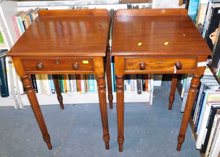 A pair of mahogany and oak side tables, in Victorian style, each with a raised back, above a...