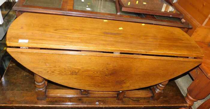 An oak low gateleg table, raised on turned legs, 47cm high, 106cm wide.