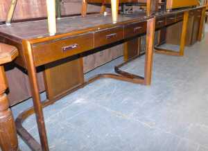 Three matching hardwood office desks, each with a three sectional leatherette panel to the top,...