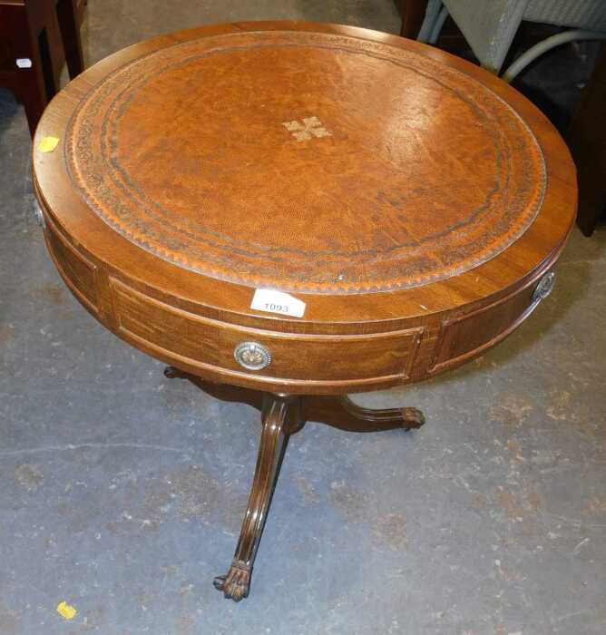 A mahogany veneer drum table, with a circular leather inset top, set on a turned pedestal base,...