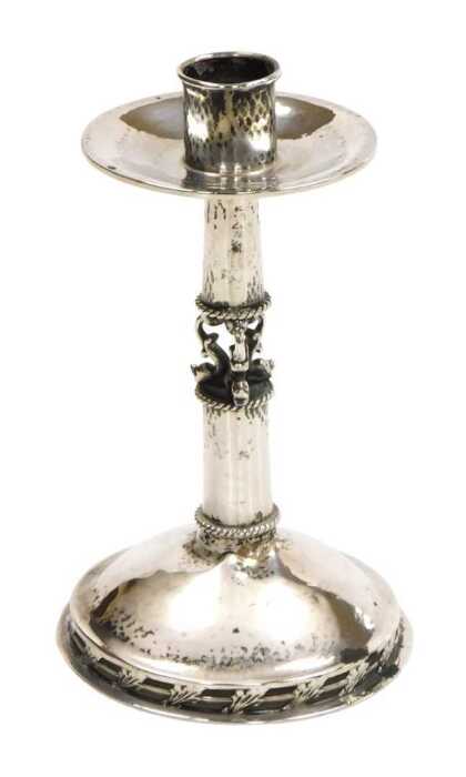 A George V Arts & Crafts silver candlestick, with hammered decoration, the mid shaft formed as...
