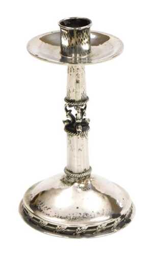 A George V Arts & Crafts silver candlestick, with hammered decoration, the mid shaft formed as...