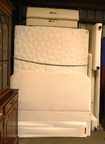 A double bed, with a cream upholstered headboard, footboard and side rails, with a mattress and...