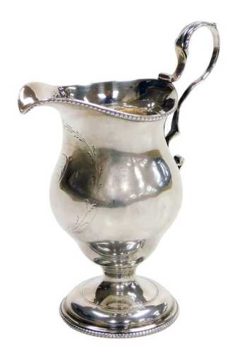A Georgian loaded silver cream jug, with beaded rims and a scroll handle, laurel wreath reserve,...