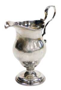 A Georgian loaded silver cream jug, with beaded rims and a scroll handle, laurel wreath reserve,...
