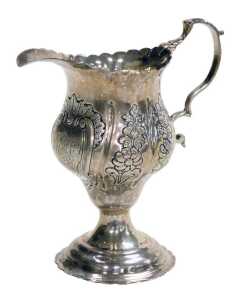A George III silver cream jug, of ogee form, with a double scroll handle, the body embossed with...