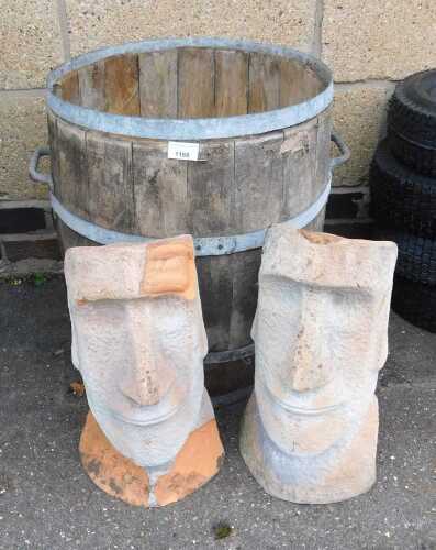 V - Two terracotta Easter Island head style garden statues, 24cm high, together with a barrel. (3)