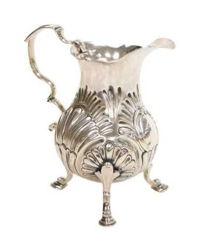 A George II silver cream jug, of pear shaped form, with a double scroll handle, embossed...