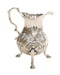 A George II silver cream jug, of pear shaped form, with a double scroll handle, embossed...