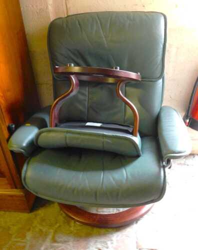A green faux leather Stressless type armchair, and footstool. (2)